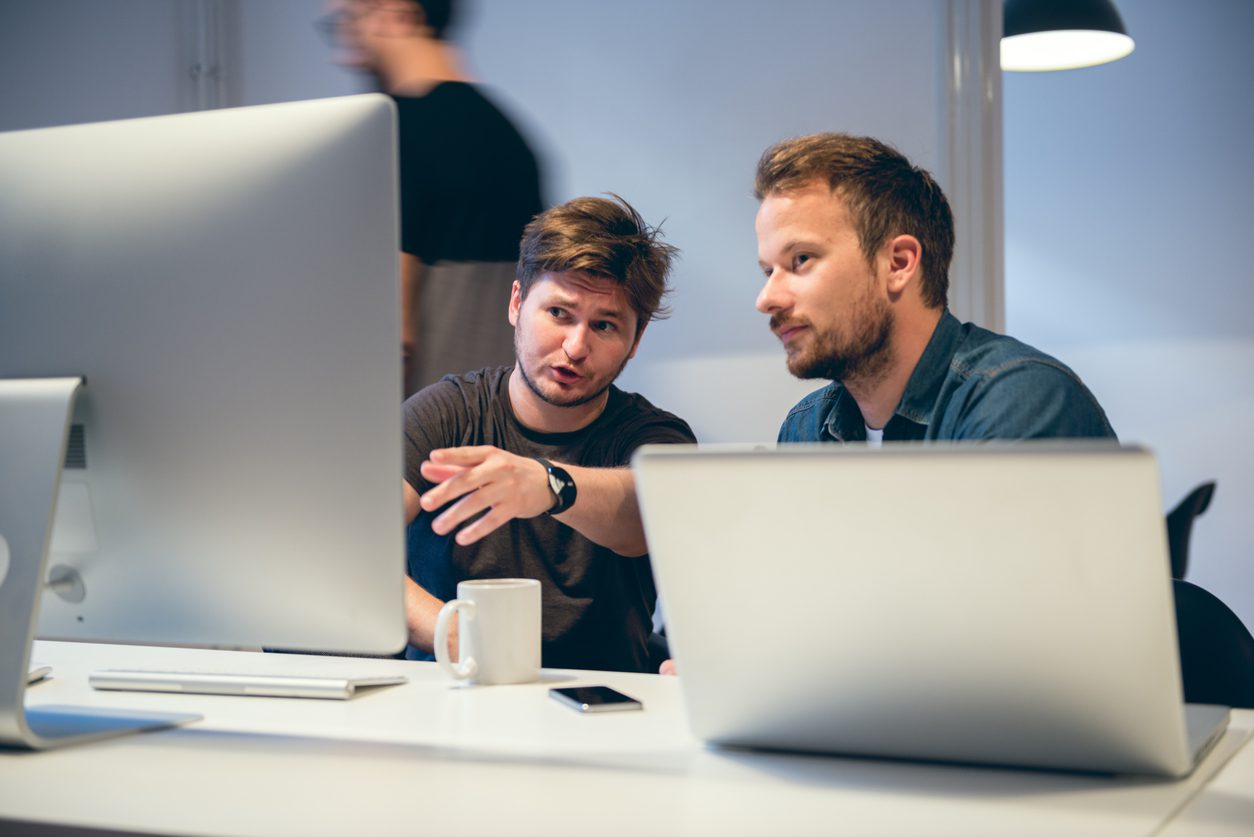 Two young men working together in office.