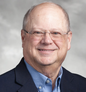 Smiling middle-aged man in glasses and suit jacket.