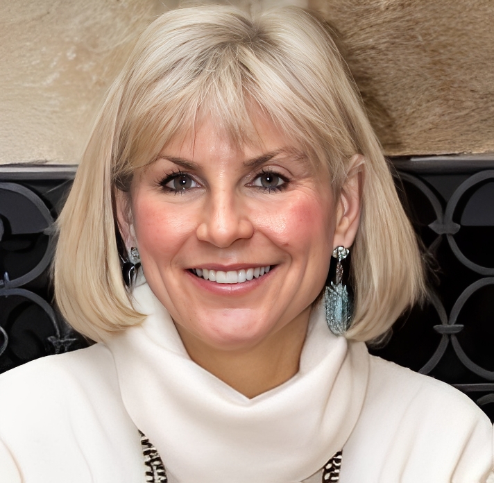 Smiling woman with blonde hair wearing a white turtleneck sweater.